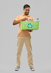 Image showing smiling young indian man sorting plastic waste