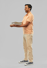 Image showing smiling young indian man sorting paper waste