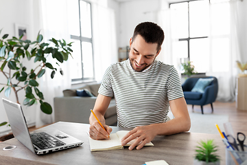 Image showing man with notebook and laptop at home office