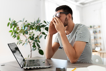 Image showing tired man with laptop working at home office