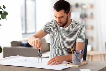 Image showing architect with blueprint working at home office