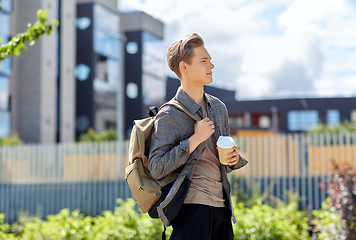 Image showing young man with backpack drinking coffee in city