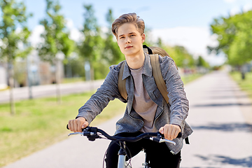 Image showing young man riding bicycle on city street