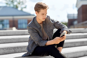 Image showing teenage boy using smartphone in city