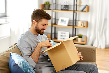 Image showing happy man opening parcel box at home