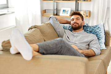 Image showing young man sleeping on sofa at home