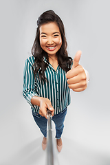 Image showing asian woman taking selfie and showing thumbs up