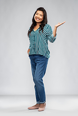 Image showing happy asian woman holding something on empty hand
