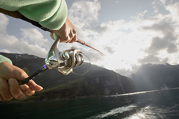 Image showing Woman fishing on Fishing rod spinning in Norway.