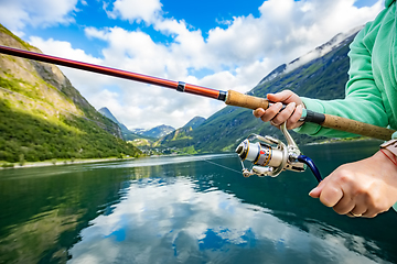 Image showing Woman fishing on Fishing rod spinning in Norway.