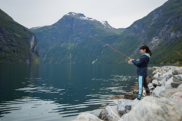 Image showing Woman fishing on Fishing rod spinning in Norway.