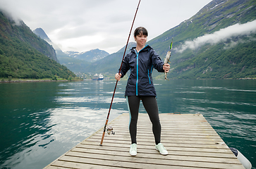 Image showing Woman fishing on Fishing rod spinning in Norway.