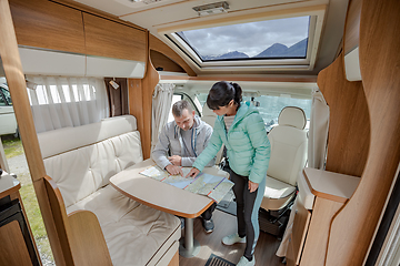 Image showing Couples in RV Camper looking at the local map for the trip.