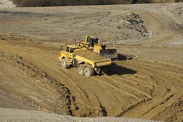 Image showing Yellow dump truck working in gravel pit