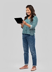 Image showing happy asian woman using tablet computer