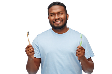 Image showing african man with wooden and plastic toothbrushes