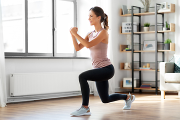 Image showing smiling young woman exercising at home