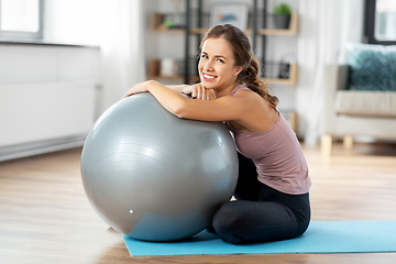 Image showing happy young woman with fitness ball at home