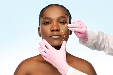 Image showing african american woman and plastic surgeon's hands