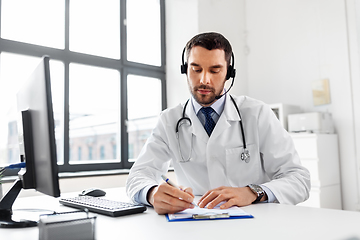 Image showing male doctor with headset and clipboard at hospital