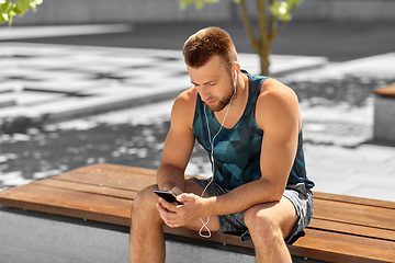 Image showing young athlete man with earphones and smartphone