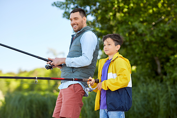 Image showing happy smiling father and son fishing on river