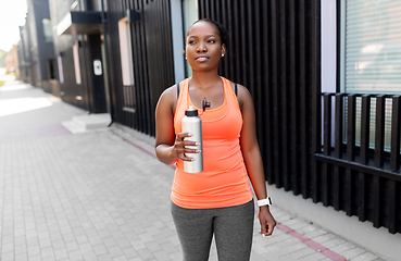 Image showing african american woman drinking water after sports