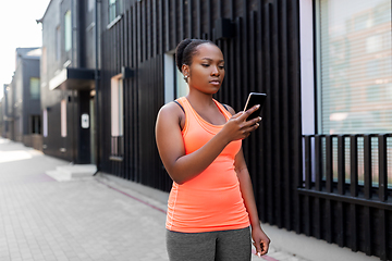 Image showing sporty african woman using smartphone in city