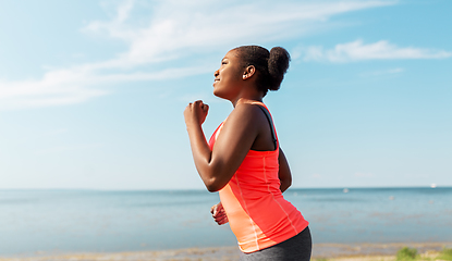 Image showing young african american woman running at seaside