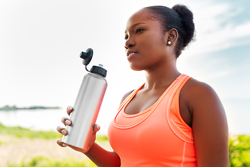 Image showing african american woman drinking water after sports