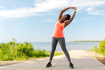 Image showing young african american woman exercising on beach