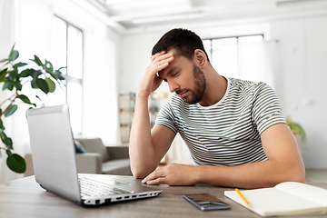 Image showing stressed man with laptop working at home office