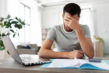 Image showing man with papers and laptop working at home office