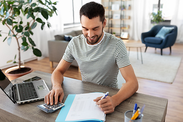 Image showing man with files and calculator works at home office