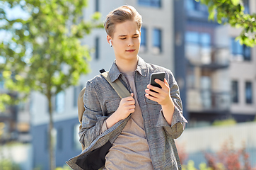 Image showing teenage boy with earphones and smartphone in city