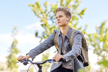 Image showing student boy with bag and earphones riding bicycle