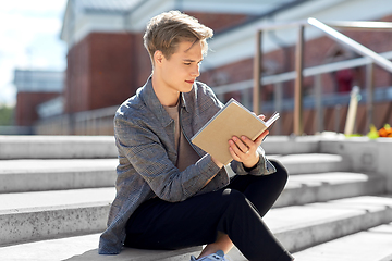 Image showing young man with notebook or sketchbook in city