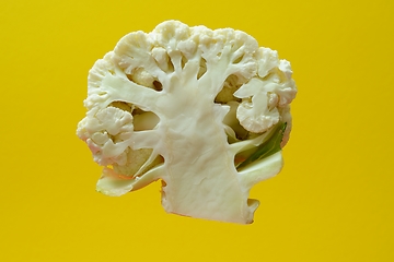 Image showing section of a head of cauliflower on a yellow backdrop