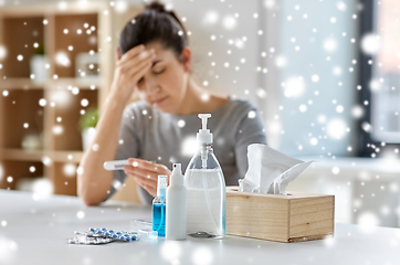 Image showing medicines and sick woman with thermometer at home