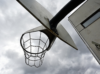 Image showing an anti-vandal basketball hoop with iron chains against a gloomy