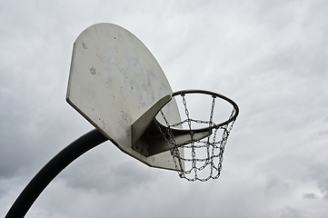 Image showing an anti-vandal basketball hoop with iron chains against a gloomy