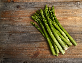 Image showing a bundle of asparagus on a wooden background with room for text