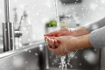 Image showing woman washing hands with liquid soap in kitchen