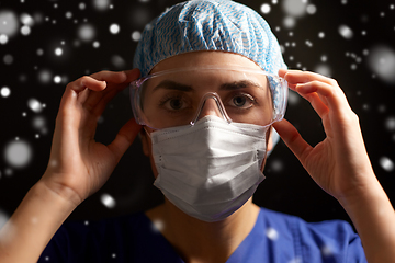 Image showing female doctor or nurse in goggles and face mask