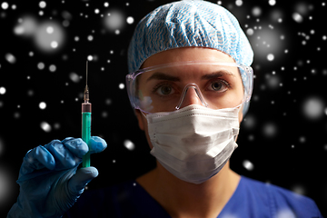 Image showing doctor in face mask and goggles holding syringe