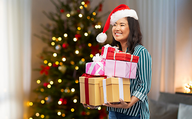 Image showing happy asian woman with christmas gifts at home