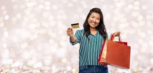 Image showing asian woman with shopping bags and credit card