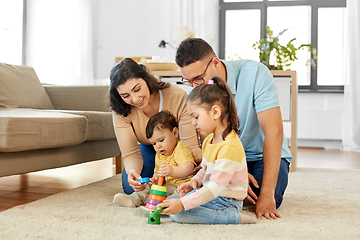 Image showing happy family playing with pyramid toy at home