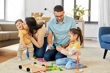 Image showing happy family palying with wooden toys at home