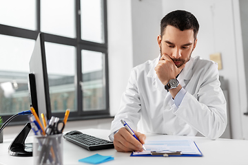 Image showing stressed male doctor with clipboard at hospital